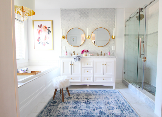 Master bathroom accessorized with art and rug and stool