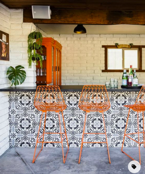 Tiled outdoor bar and orange barstools